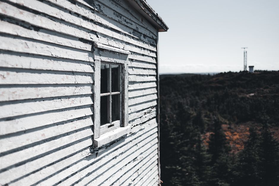 Weathered wooden house wall with peeling paint